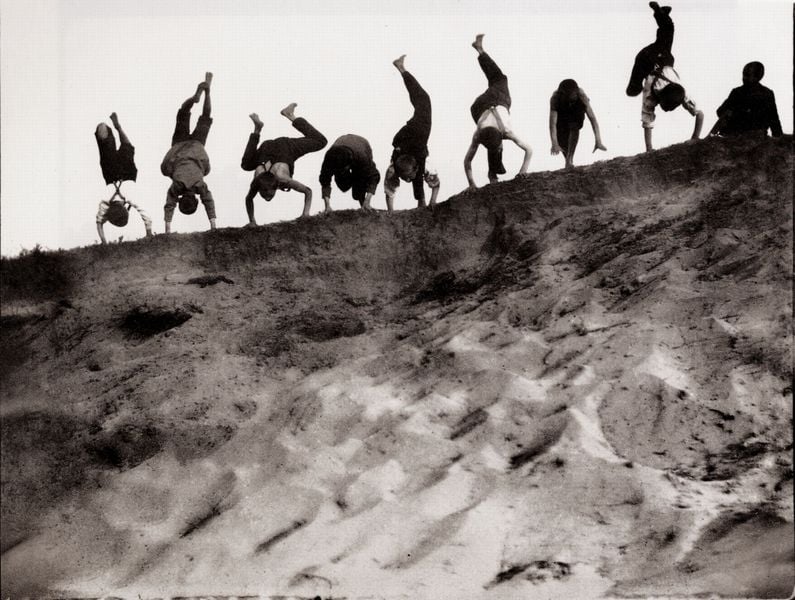 Acht Jungen üben Handstand. by Heinrich Zille. 1890–1910. Motifs recorded: sand, düne, handstand, menschen, hosenträger, fotografie, kopfstand, foto.