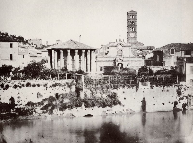 Ansicht der Piazza di Bocca della Verità vom Ponte Rotto aus. 1858–1862. Motifs recorded: kirche, turm, foto, tempel, säulen, uhr, mauer, fluss.