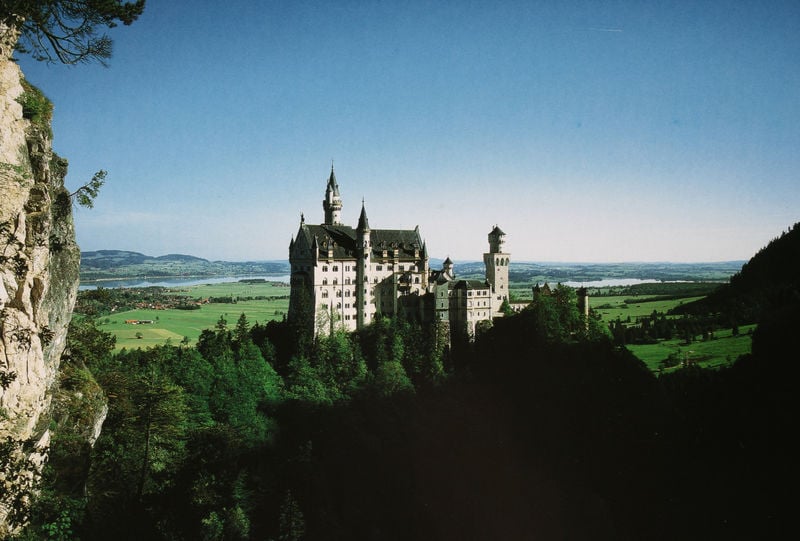Blick von der Marienbrücke über die Pöllatschlucht auf Neuschwanstein vor der Ebene von Schwangau mit dem Forggensee. by Georg Dollmann. 1868–1886. Motifs recorded: türme, castle, neuschwanstein, grün, himmel, schloss, trees, felsen.