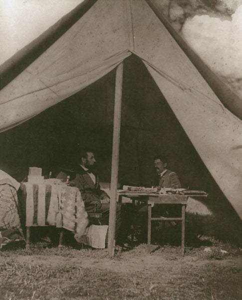Abraham Lincoln et le général McLellan à la Bataille d’Antietam. by Alexander Gardner. 1862. Motifs recorded: zelt, tisch, männer, foto, schwarzweiß, gras, gespräch, lincoln.
